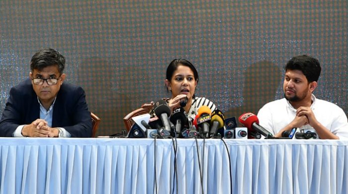 a group of people sitting at a table with microphones